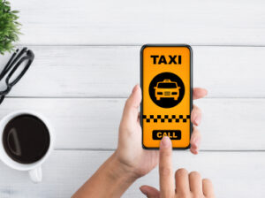woman-holding-smartphone-with-taxi-app-interface-2023-11-27-05-09-36-utc-1.jpg